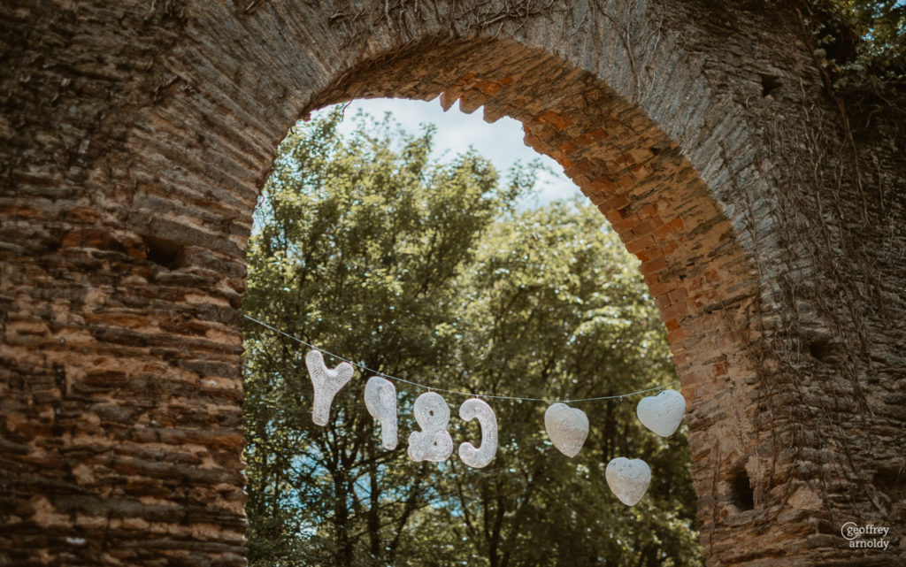 déco de mariage maillO design, initiale des mariés et coeurs dentelle pour cérémonie laïque dans l'ancienne forge du Manoir de la Jahotiere à Abbaretz en pays de la Loire