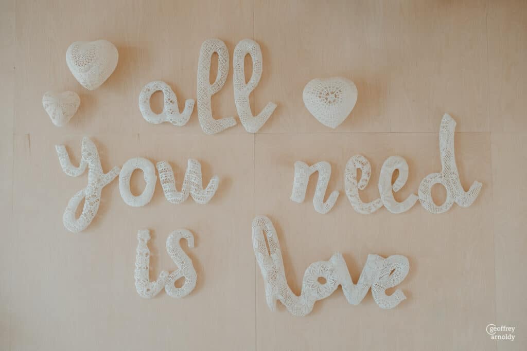 décoration de mariage All you need is Love en lettre dentelle blanches sur mur au domaine quatre plume aux Landes Genusson